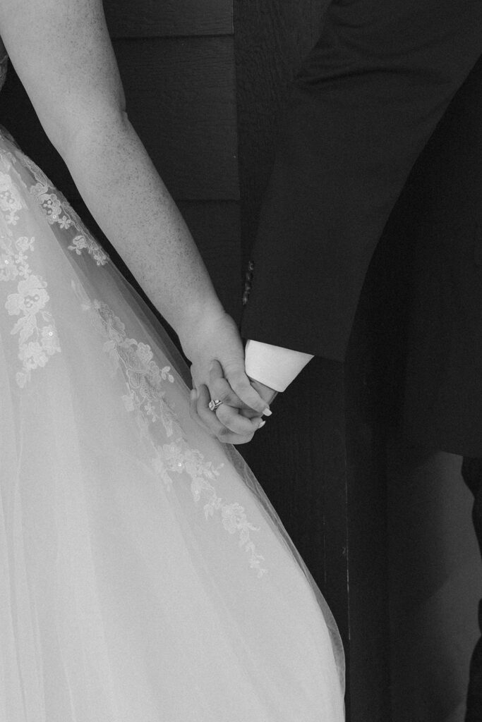 Destination elopement photographer captures close up of bride and groom holding hands during destination elopement in Iceland