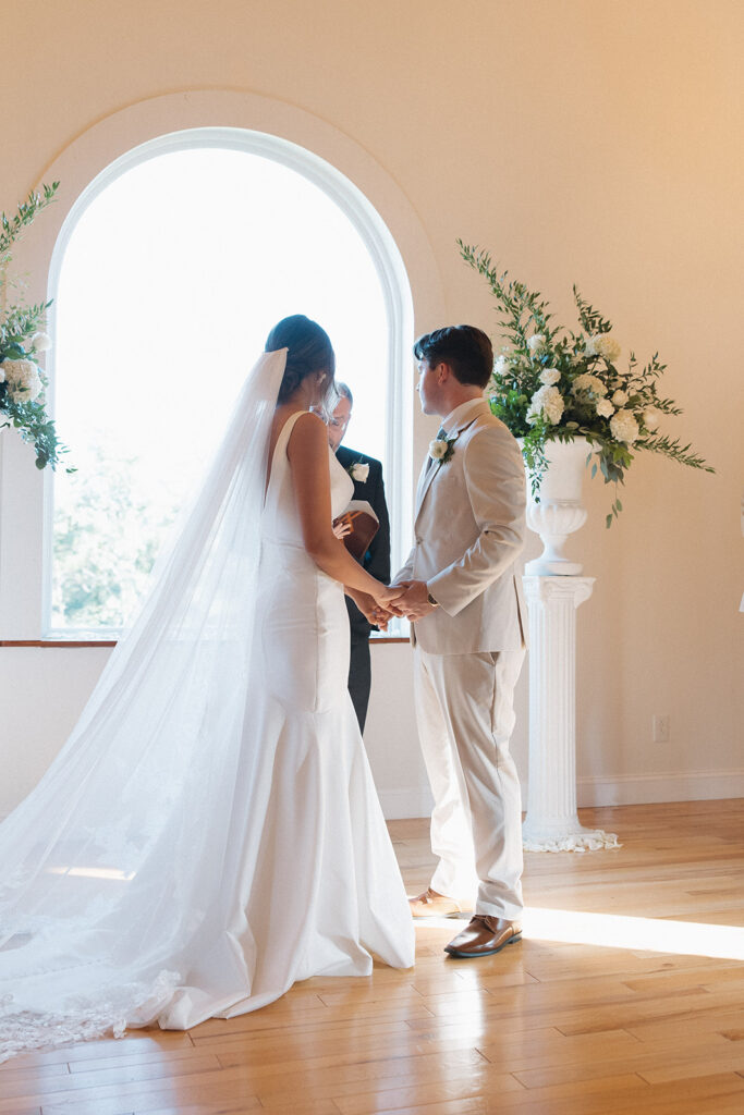 Tennessee wedding photographer captures bride and groom holding hands during wedding ceremony