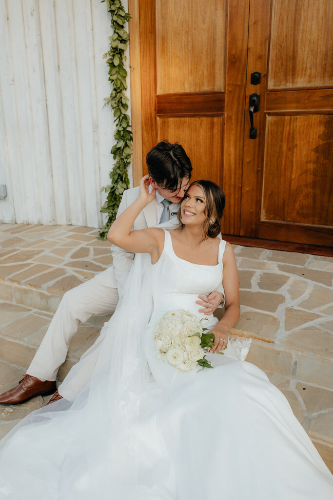 Destination elopement photographer captures bride and groom sitting together on church steps