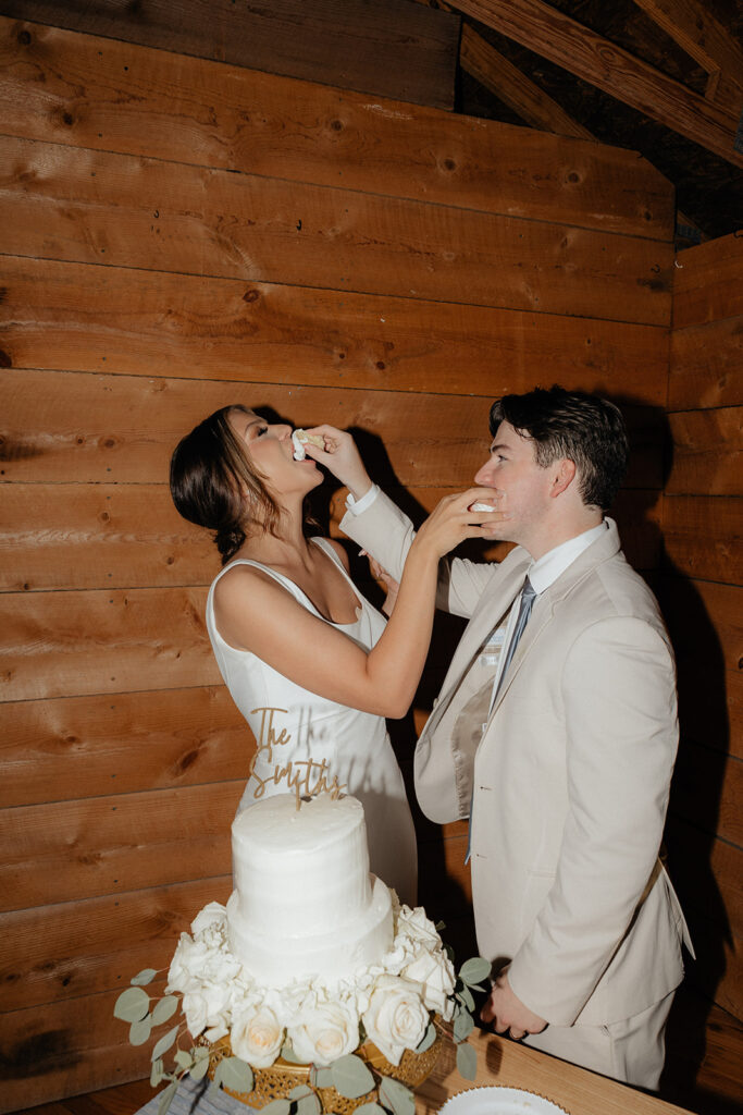 Tennessee wedding photographer captures bride and groom putting cake into one another's mouths