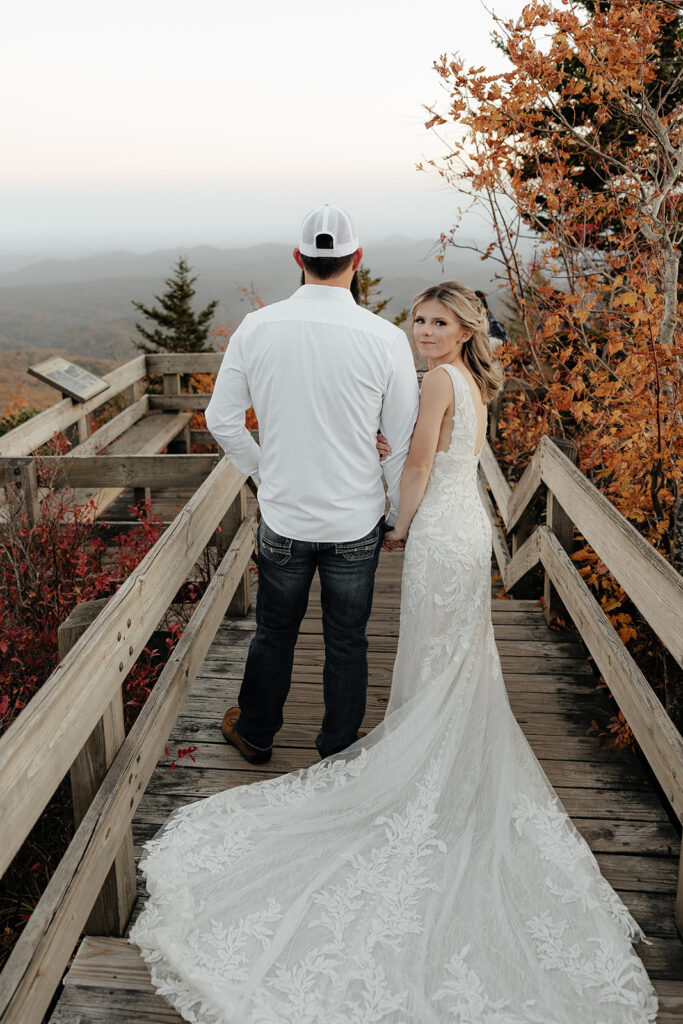 Destination wedding photographer captures bride holding groom's arm while looking over shoulder 