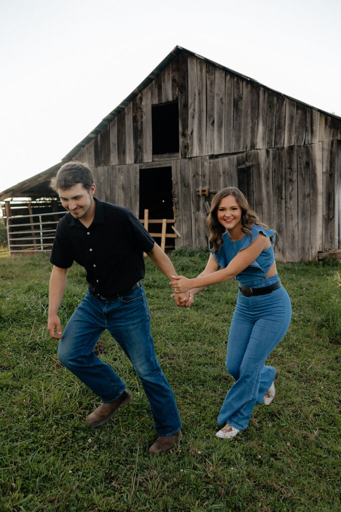 Tennessee elopement photographer captures man running with woman away from barn during mountain engagement photos