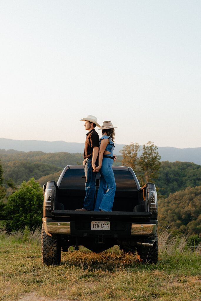 Tennessee elopement photographer captures man and woman standing in bed of truck holding hands